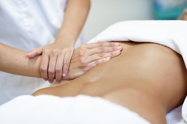 maos massageando o abdomen feminino therapista aplicando pressao sobre a barriga 1139 11241